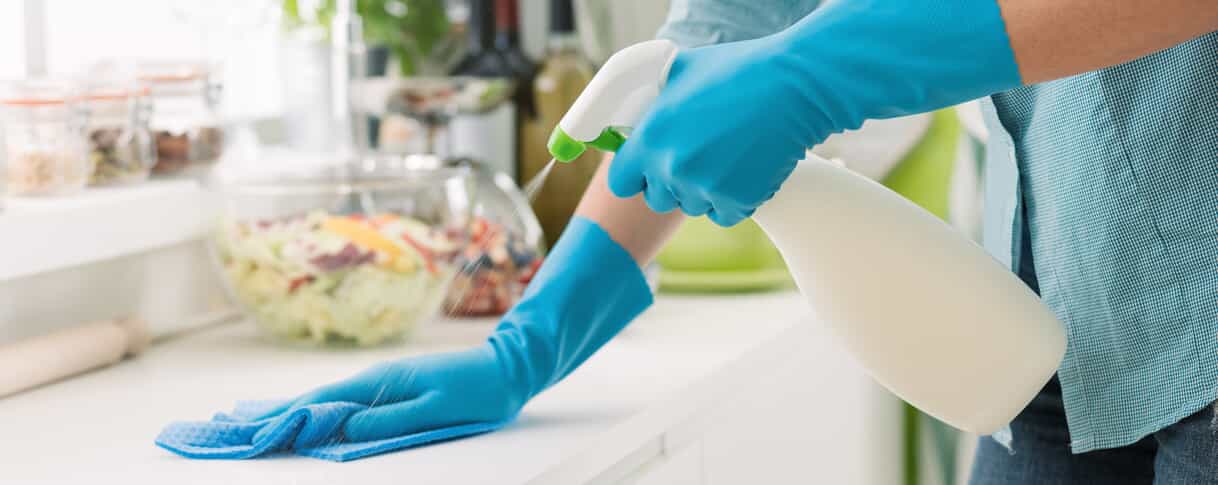 A person cleaning a kitchen counter